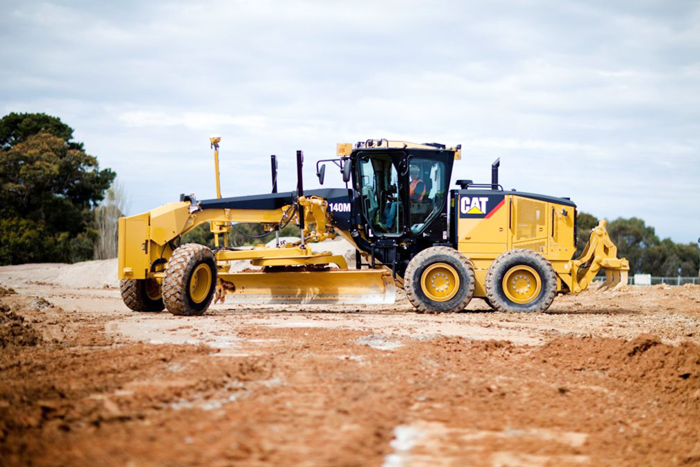 Motor grader working a desert road in Nye County